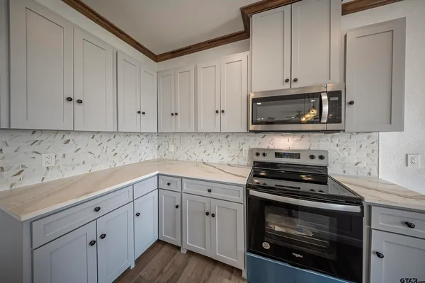 a kitchen with cabinets appliances a sink and a counter space