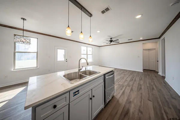 a kitchen with a sink window and wooden floor
