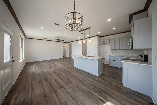 a view of a kitchen with wooden floor and windows