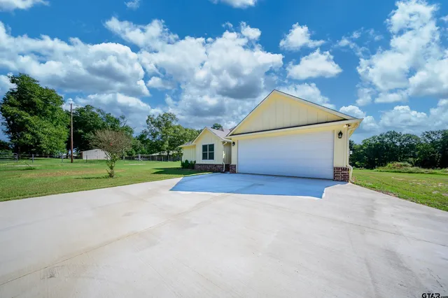 a aerial view of a house next to a yard with big yard
