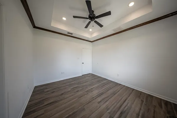 a view of room with a ceiling fan and wooden floor