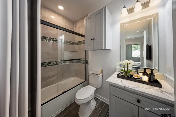 a bathroom with a granite countertop sink toilet and shower