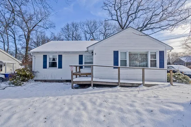 a white house that has a tree in front of it