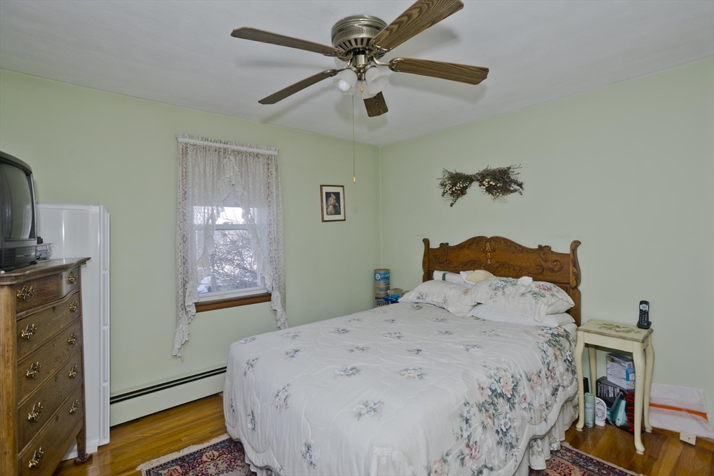 129 Cooper Street Springfield, MA 01108 - Photo 15 of 26 a bedroom with a bed and a chandelier
