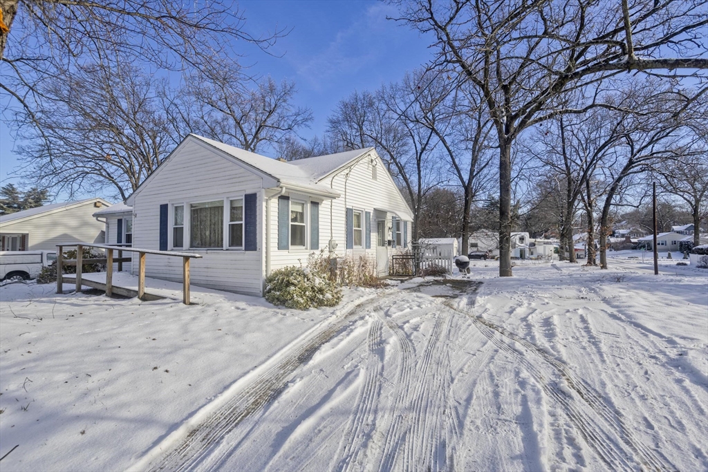 129 Cooper Street Springfield, MA 01108 - Photo 3 of 26 a front view of a house with a yard covered in snow