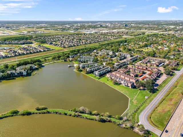 an aerial view of residential houses with outdoor space and ocean view