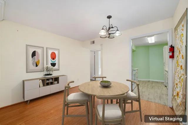 a view of an empty room with wooden floor and window