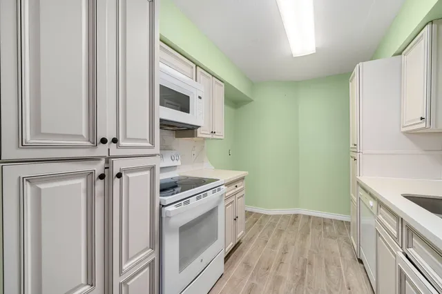 a kitchen with stainless steel appliances white cabinets and a sink