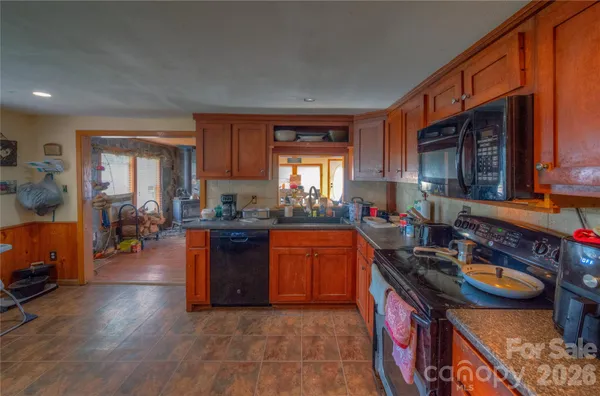a kitchen with stainless steel appliances granite countertop sink stove top oven and cabinets