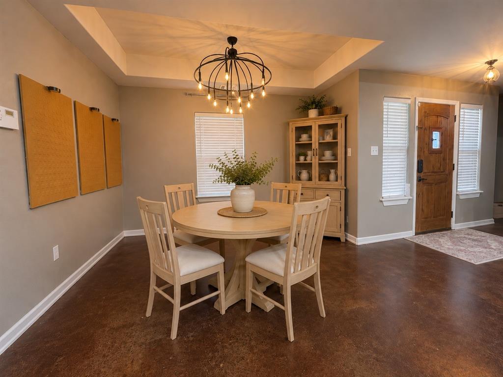 420 Sessums Road Springtown, TX 76082 - Photo 6 of 40 Breakfast area featuring a tray ceiling, contemporary chandelier, and stained concrete finish flooring-virtually staged,