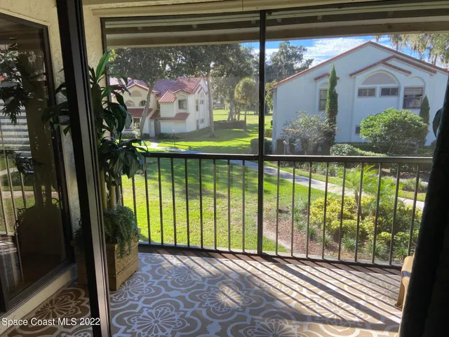 a view of a porch with a floor to ceiling window and tree