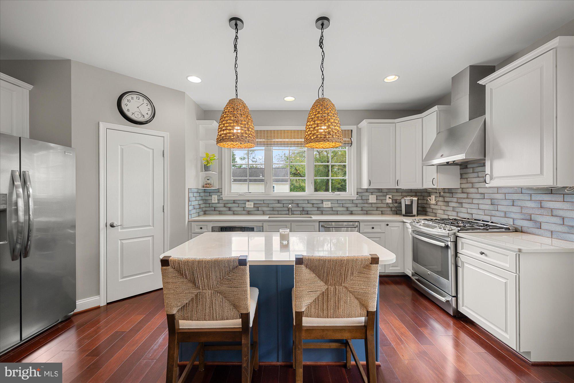 8808 Walnut Hill Road Chevy Chase, MD 20815 - Photo 18 of 60 a kitchen with stainless steel appliances granite countertop a kitchen island a stove a table and a refrigerator