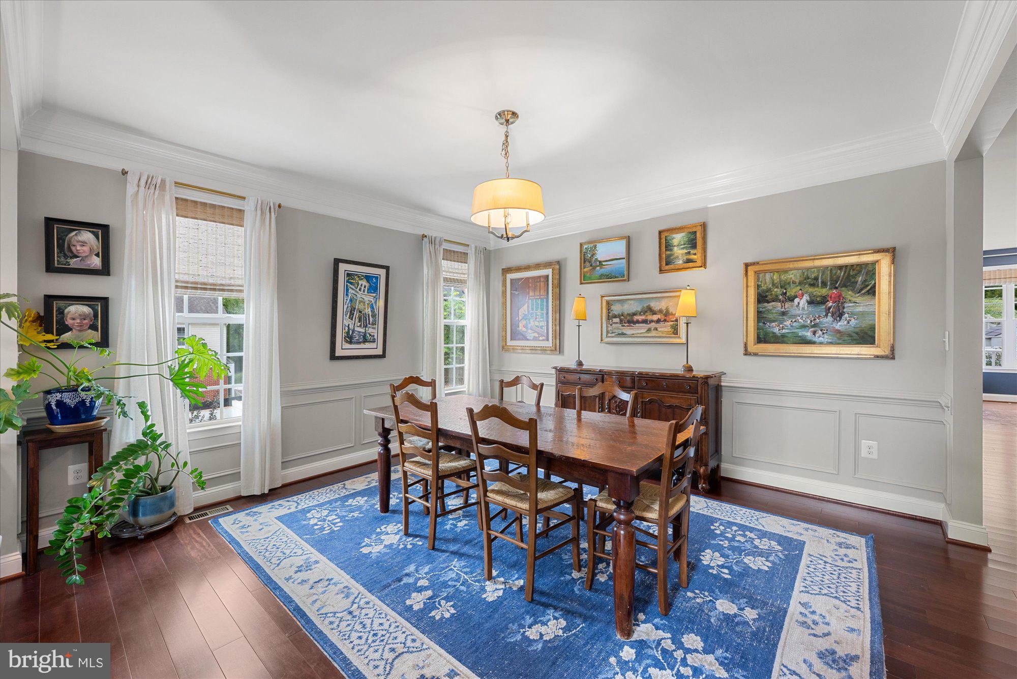 8808 Walnut Hill Road Chevy Chase, MD 20815 - Photo 8 of 60 a dining room with wooden floor a chandelier a wooden table and chairs