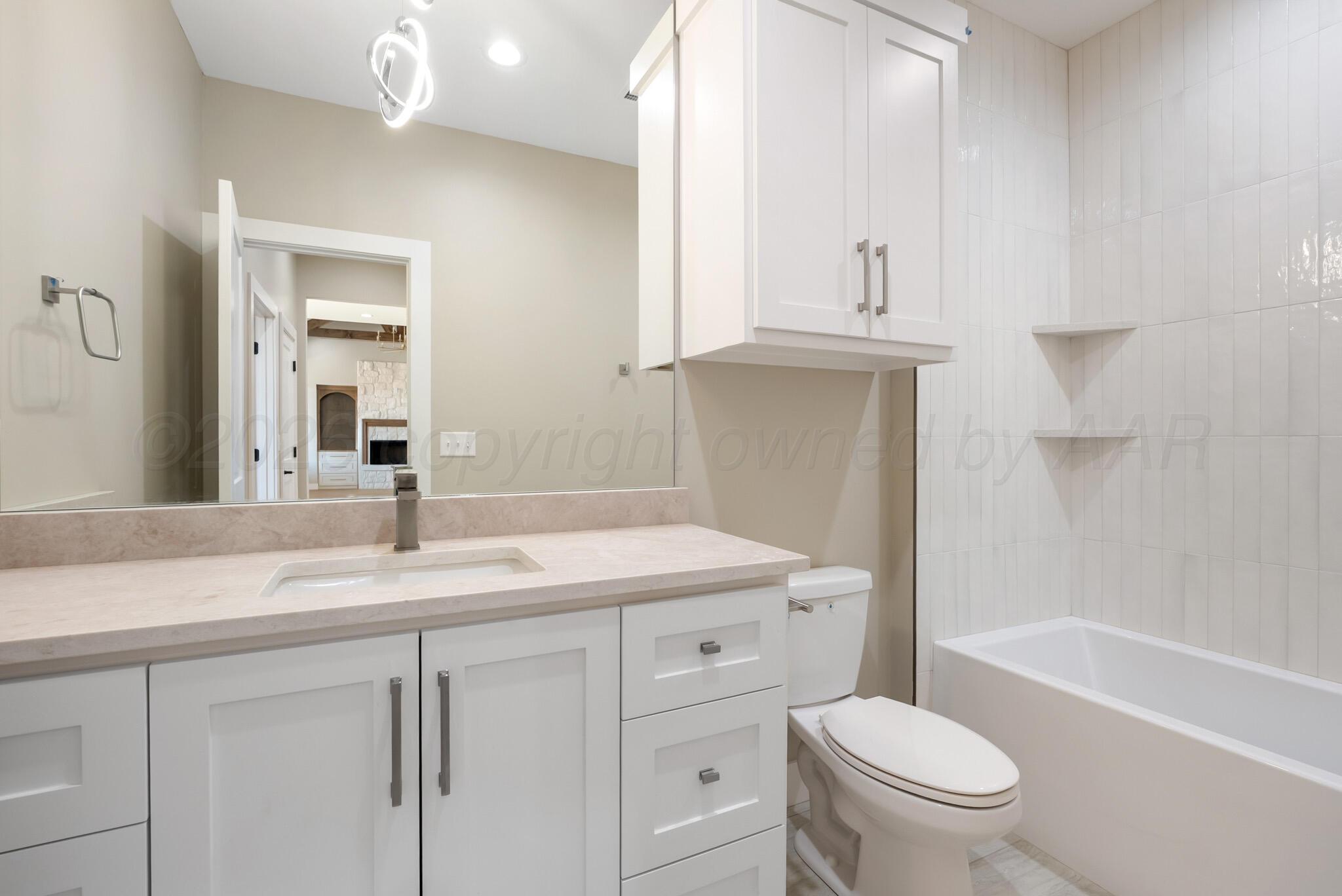 4201 Juniper Springs Road Amarillo, TX 79119 - Photo 24 of 27 a bathroom with a granite countertop sink toilet mirror and bathtub