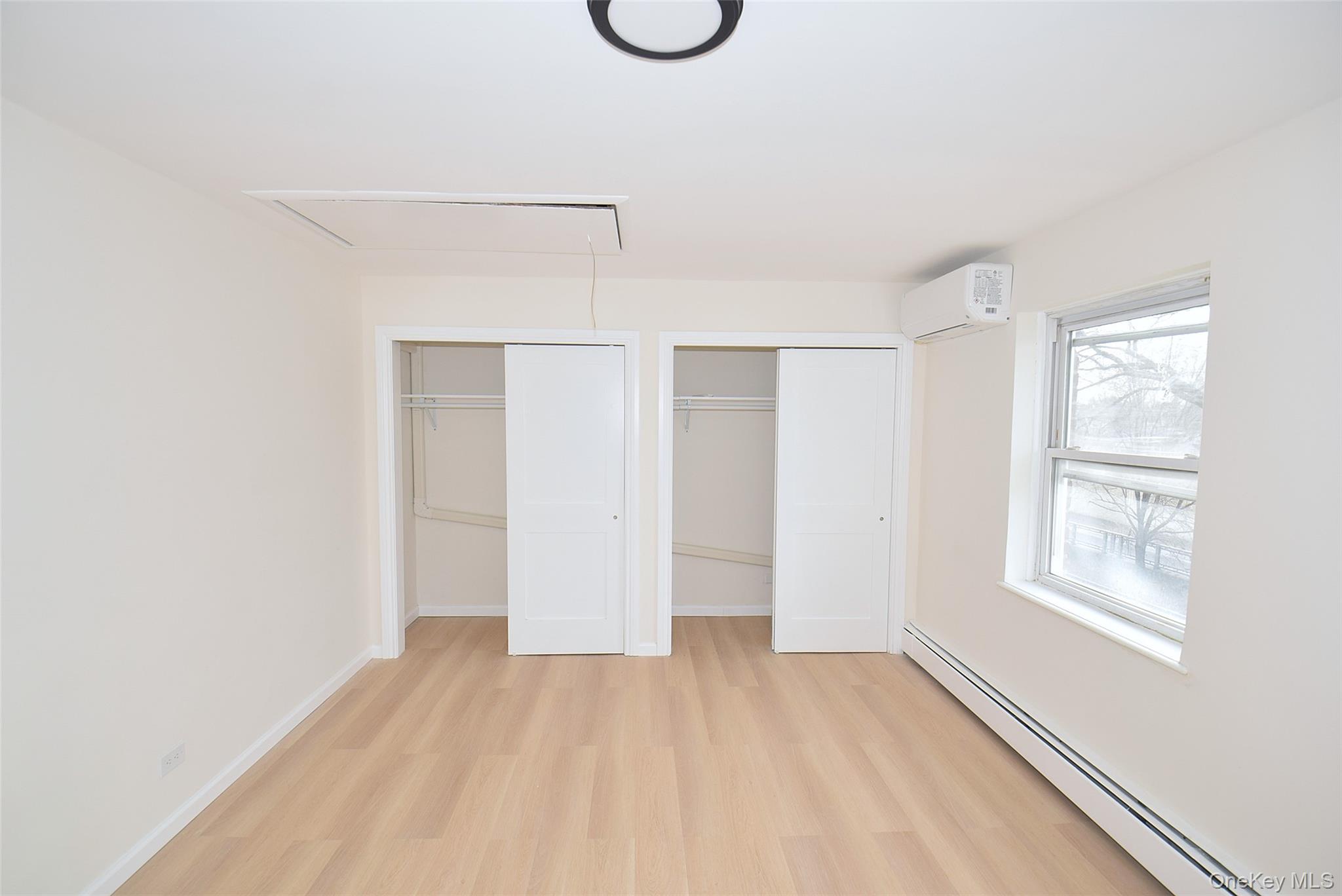 144-24 Village Road, Unit 67B Queens, NY 11435 - Photo 13 of 17 a view of an empty room with wooden floor and windows