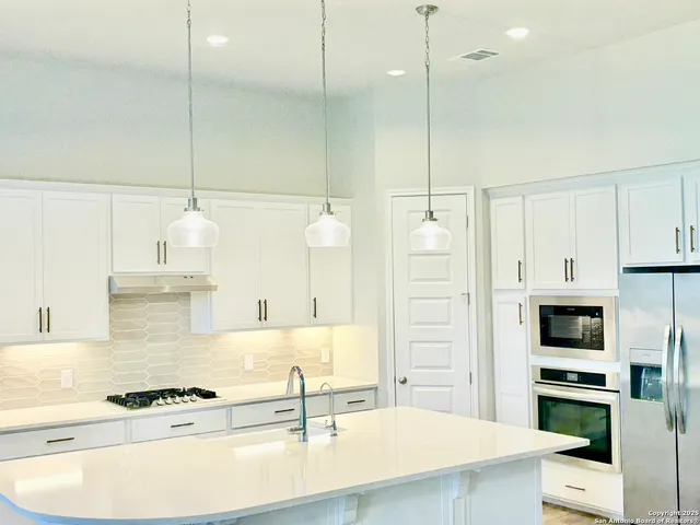 a kitchen with kitchen island white cabinets and stainless steel appliances