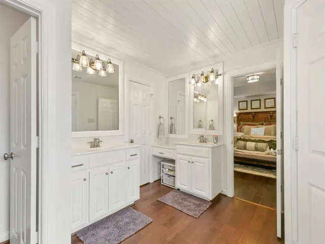 a spacious bathroom with a double vanity sink a mirror and a bathtub