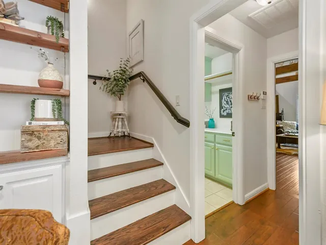 a view of a hallway with wooden floor and staircase
