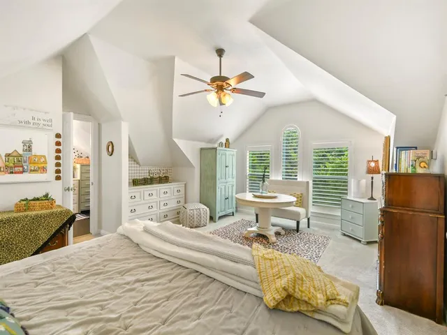 a bedroom with a bed and large windows