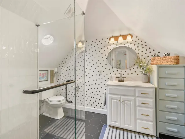 a bathroom with a sink a toilet and shower