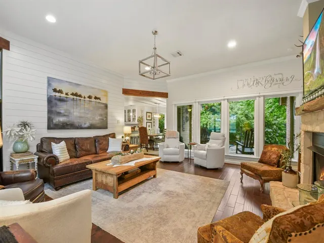 a living room with furniture ceiling fan and a large window