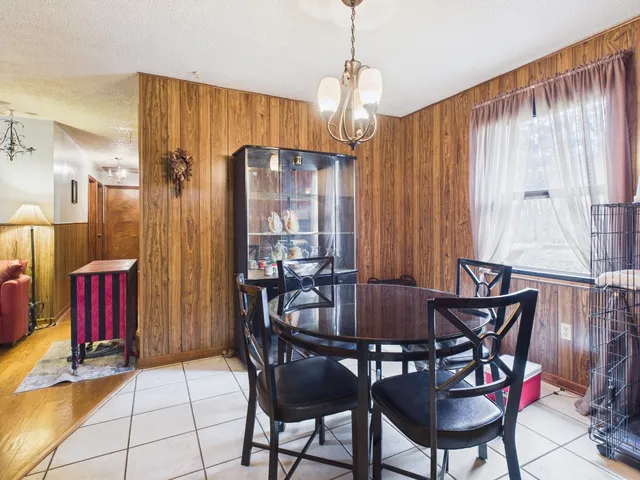 a view of a dining room with furniture and chandelier