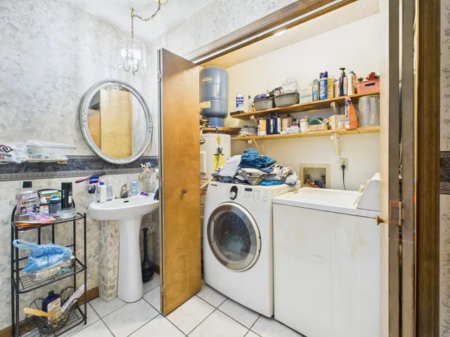 a utility room with dryer washer and a view of living room