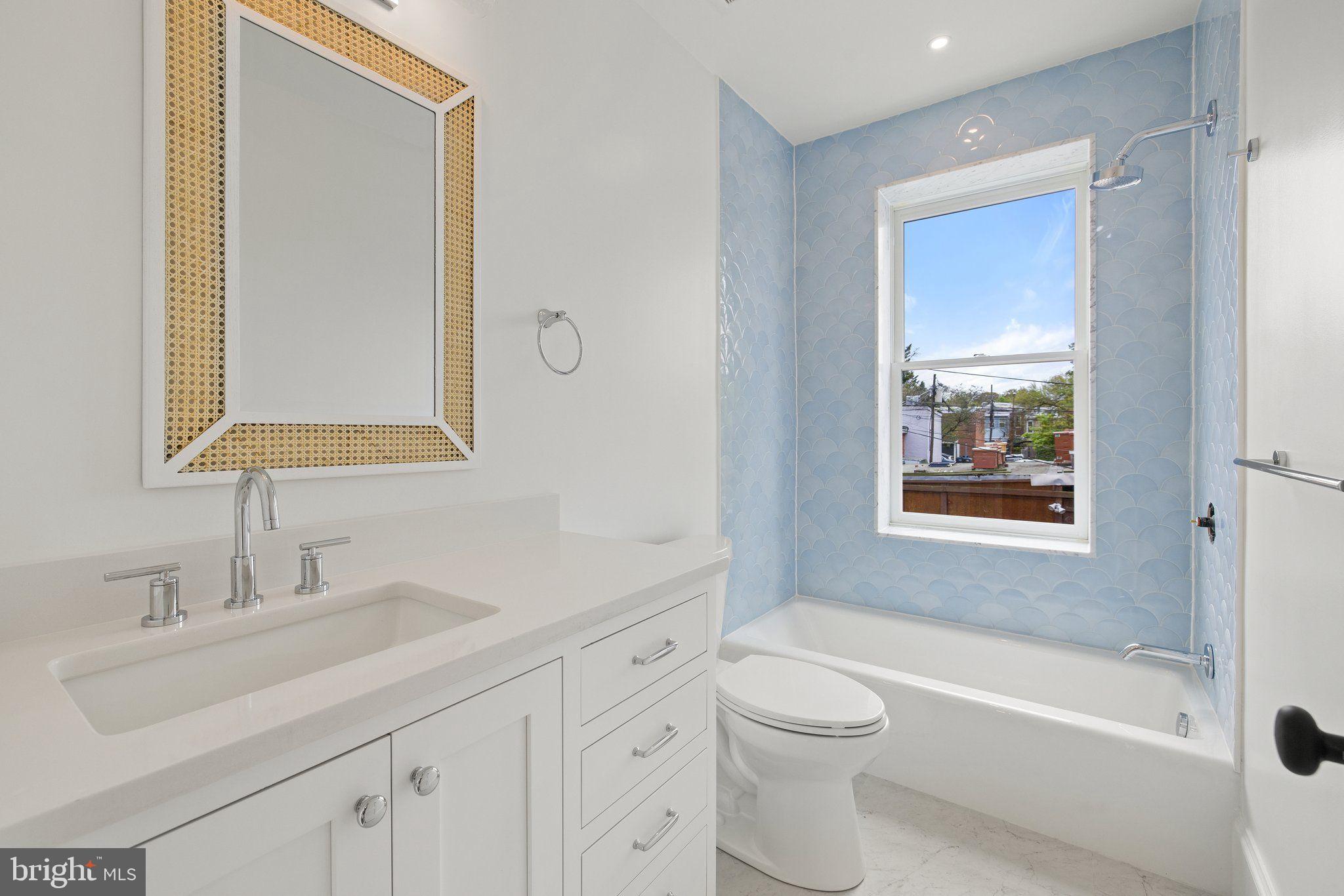 243 10th Street Northeast Washington, DC 20002 - Photo 60 of 73 a bathroom with a toilet a sink a mirror a bathtub and vanity