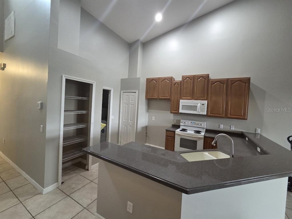2642 Rutledge Court Winter Haven, FL 33884 - Photo 4 of 6 a kitchen with kitchen island granite countertop a sink counter top space appliances and cabinets