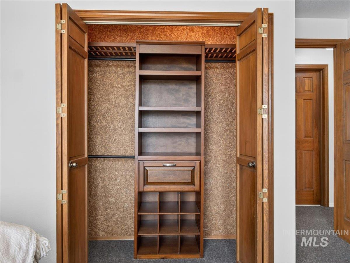 8989 Hillview Road Emmett, ID 83617 - Photo 26 of 50 Built-in closet organization system featuring a central shelving unit, pull-out drawer, and lower cubbies, all framed by bifold wood doors