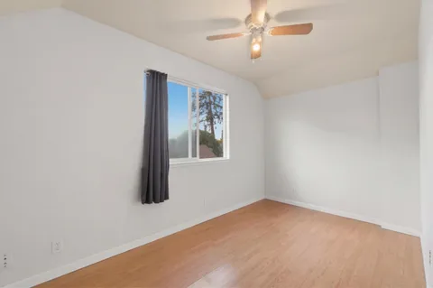 an empty room with windows and fan