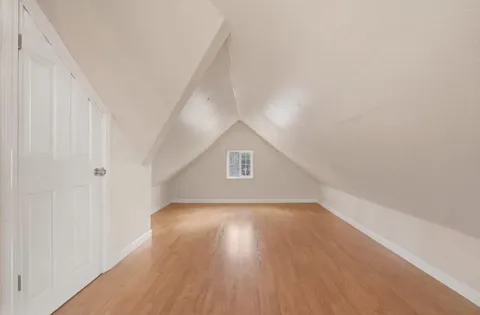 a view of a small space with wooden floor and a window