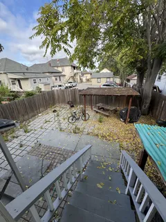 a view of a roof deck with couches and wooden fence