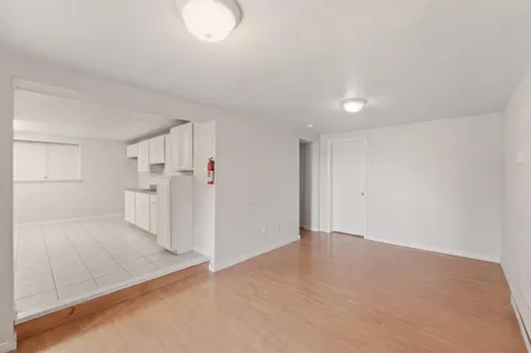 an empty room with a cabinet and mirrors