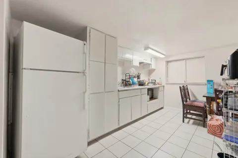 a kitchen with white cabinets and white appliances