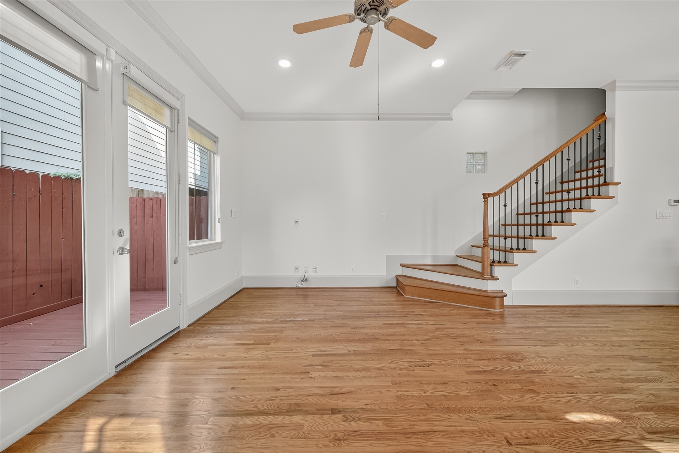 931 West 23rd Street, Unit K Houston, TX 77008 - Photo 6 of 40 Family room showcases the outdoors through the large windows with Hunter Douglas shades and door leading the private patio.