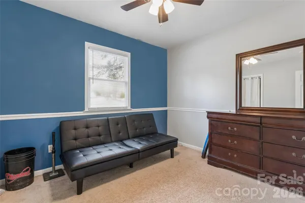 a living room with couches and a dresser with wooden floor