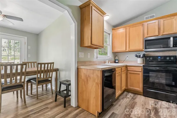 a kitchen with a stove sink microwave and cabinets