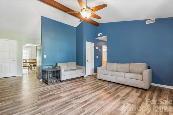 a living room with furniture and a wooden floor