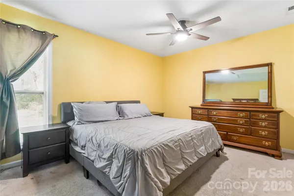 a bedroom with a bed and a chandelier with a flat tv screen
