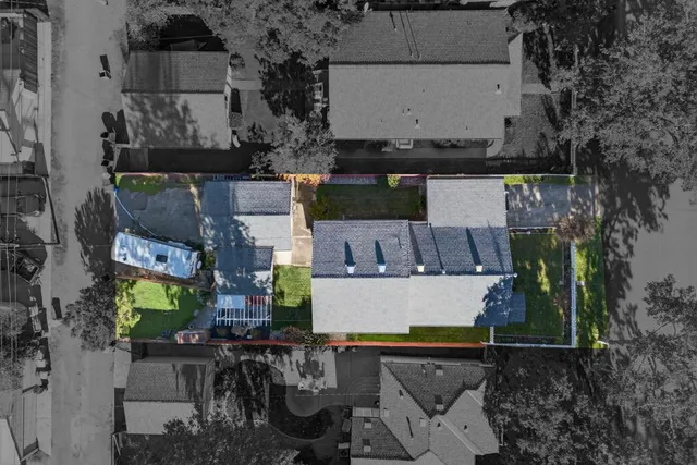 an aerial view of a house with garden space and a car park in the back