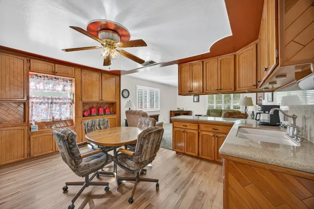 a kitchen with granite countertop a sink a counter space dining table and stainless steel appliances