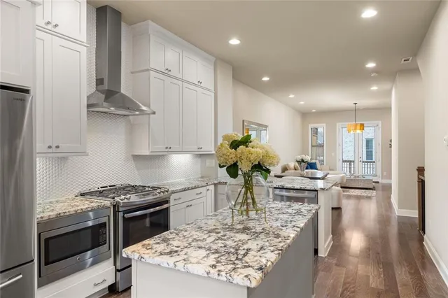 a kitchen with stainless steel appliances granite countertop a sink stove and refrigerator