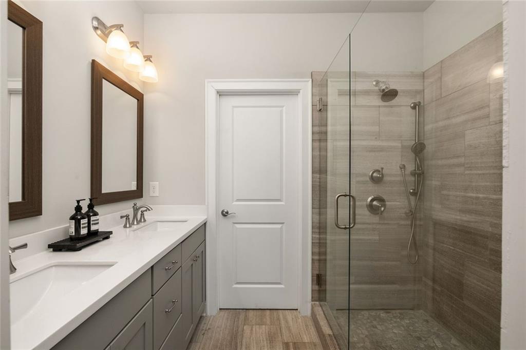 4751 Roswell Road Atlanta, GA 30342 - Photo 18 of 36 a bathroom with a double vanity sink mirror and shower
