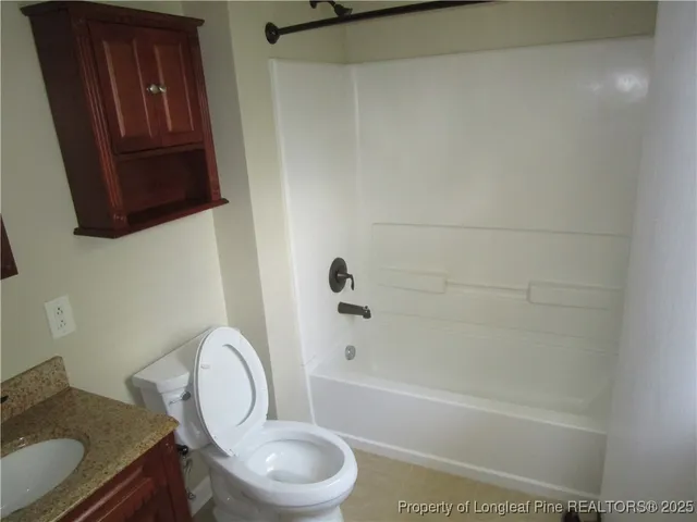 a bathroom with a granite countertop toilet a sink and bathtub