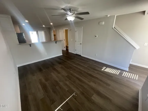 a view of empty room with wooden floor