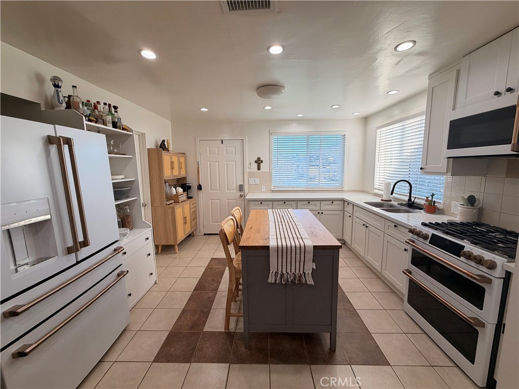 30009 Hunstock Street Castaic, CA 91384 - Photo 9 of 23 a kitchen with granite countertop a refrigerator and a stove top oven