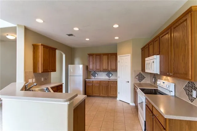 a kitchen with a stove sink and cabinets