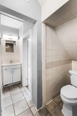 a bathroom with a toilet sink and a mirror