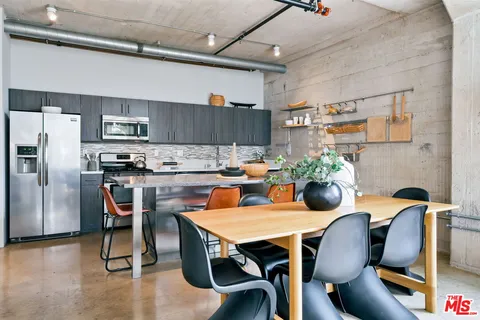 a dining room with furniture and kitchen view